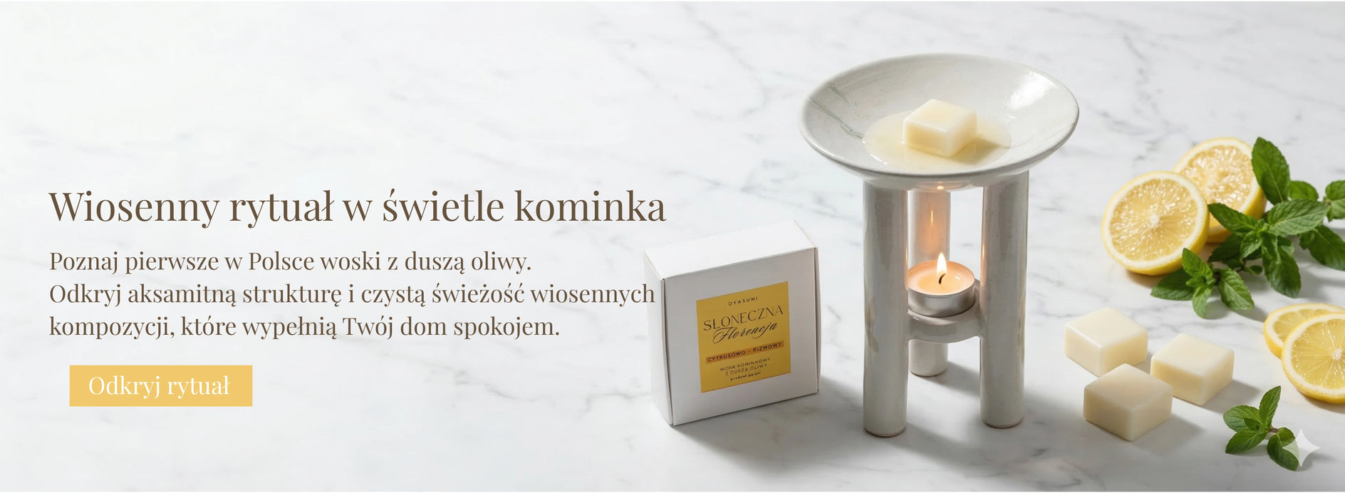 Centralne zbliżenie na ceramiczny kominek zapachowy Oyasumi z topiącą się kostką wosku oliwnego. U dołu widoczny delikatny płomień tealighta. Obok kominka znajduje się białe pudełko „Słoneczna Florencja” oraz świeże plasterki cytryny i listki mięty na tle jasnego marmuru. Kompozycja pionowa, podkreślająca detale produktu i aksamitną strukturę wosku.