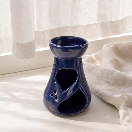 Granatowy ceramiczny kominek zapachowy Oyasumi w jasnym wnętrzu przy oknie