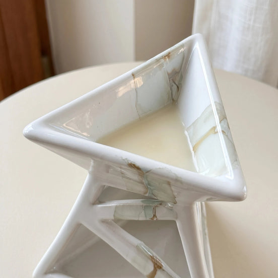 Zbliżenie ceramicznego kominka zapachowego z roztopionym woskiem w górnej misie