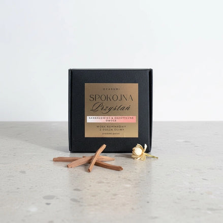 Naturalny wosk oliwny Oyasumi obok kawałków drewna sandałowego i białego kwiatu jaśminu