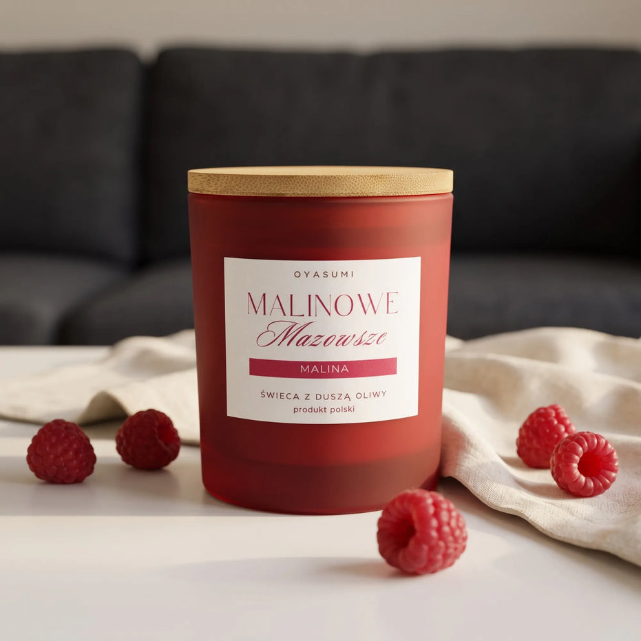 Świeca zapachowa Oyasumi Malinowe Mazowsze o zapachu maliny wykonana z 100% wosku oliwnego, otoczona świeżymi malinami w eleganckiej aranżacji.