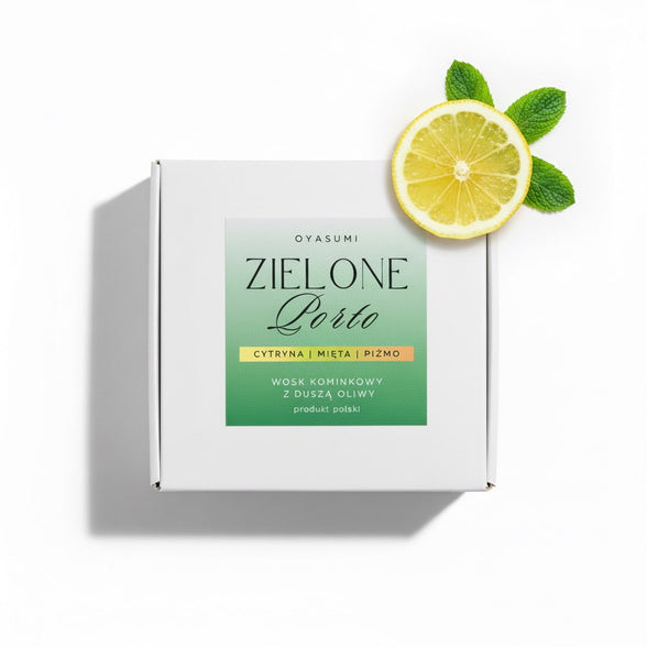 Białe pudełko wosku zapachowego Oyasumi Zielone Porto z plasterkiem cytryny i listkami mięty na białym tle.