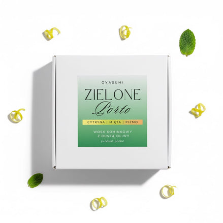 Widok z góry na wosk Zielone Porto otoczony listkami mięty i spiralną skórką z cytryny na białym tle.